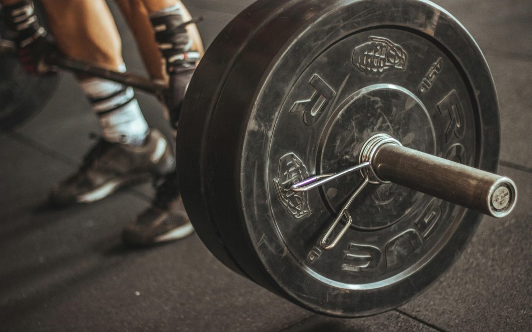 Halterstang met gewichtsschijven op de vloer van Cave Gym in Gouda